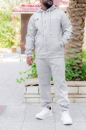 طقم رجالي شتوي قطعتين لون رمادي فاتح ببلوفر هودي قبعة متصلة برباط و بسحاب و جيوب أمامية مزين بكتابات مع بنطلون طويل بجيوب من الجانبين