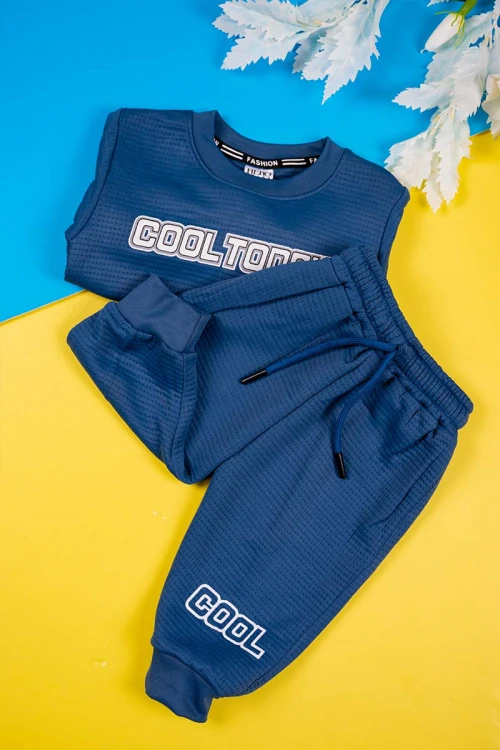 طقم قطعتين ولادي لون كحلي مزين بكتابات بأكمام طويلة مع بنطلون طويل برباط في الخصر و زم في الأطراف