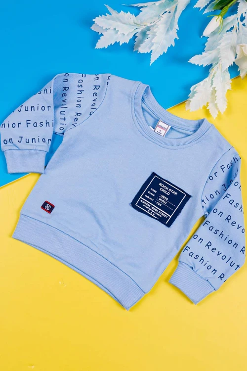 طقم قطعتين ولادي بلوزة لون سماوي مزينة بكتابات من الأمام و الخلف و بأكمام طويلة مع بنطلون كحلي طويل برباط في الخصر و زم في الأطراف