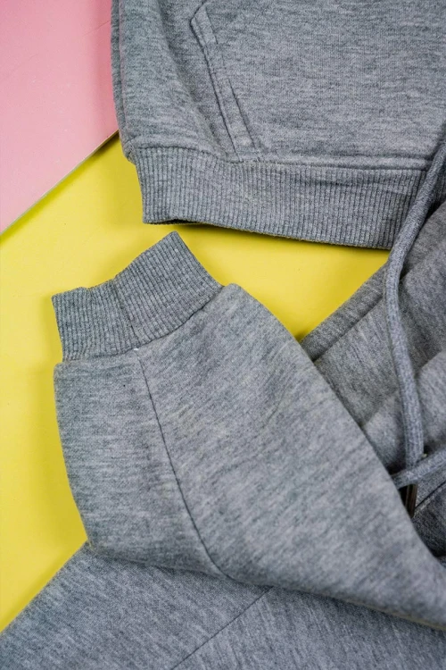 طقم قطعتين ولادي لون رمادي بلوزة بياقة عالية و بسحاب مزينة بكتابات و بجيب الكنغر من الأمام و بأكمام طويلة مع بنطلون طويل برباط في الخصر و زم في الأطراف