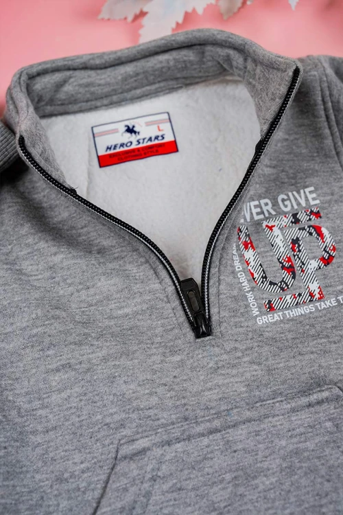 طقم قطعتين ولادي لون رمادي بلوزة بياقة عالية و بسحاب مزينة بكتابات و بجيب الكنغر من الأمام و بأكمام طويلة مع بنطلون طويل برباط في الخصر و زم في الأطراف