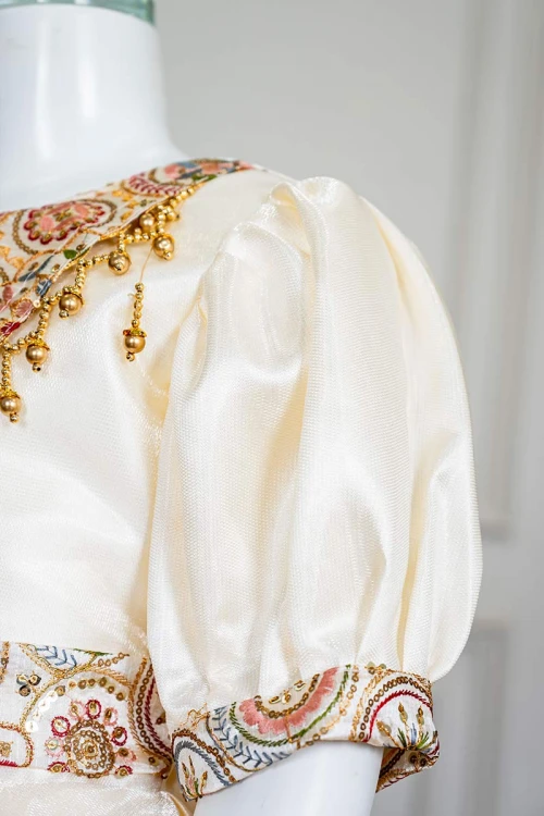 فستان بناتي طويل لون بيج فاتح مزين بتطريز ملون من الياقة و أطراف الأكمام و بحزام في الخصر