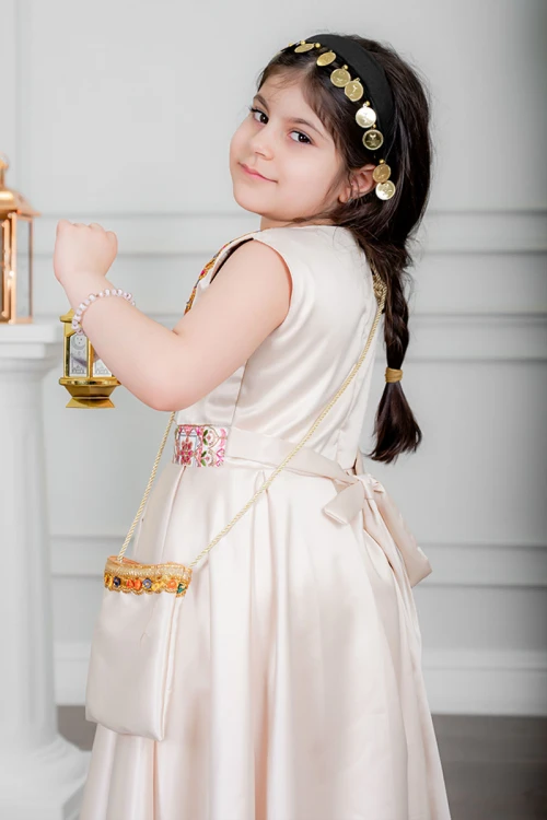 فستان بناتي تراثي لون بيج بتطريز تراثي ملون من الأمام و برباط في الخصر بدون أكمام مع قماش شيفون من الخارج و شنطة