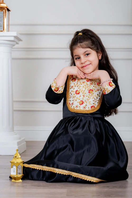 فستان بناتي تراثي قصير لون أسود مزين بتطريز ذهبي و بزخارف من الأمام و الأكمام