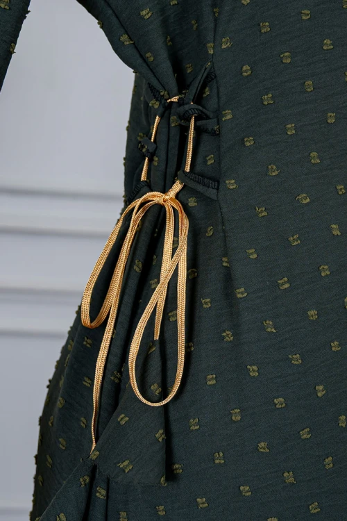 جلابية نسائية لون زيتي منقطة و مزينة بكلفة في الياقة و الأكمام و برباط في الجانبين