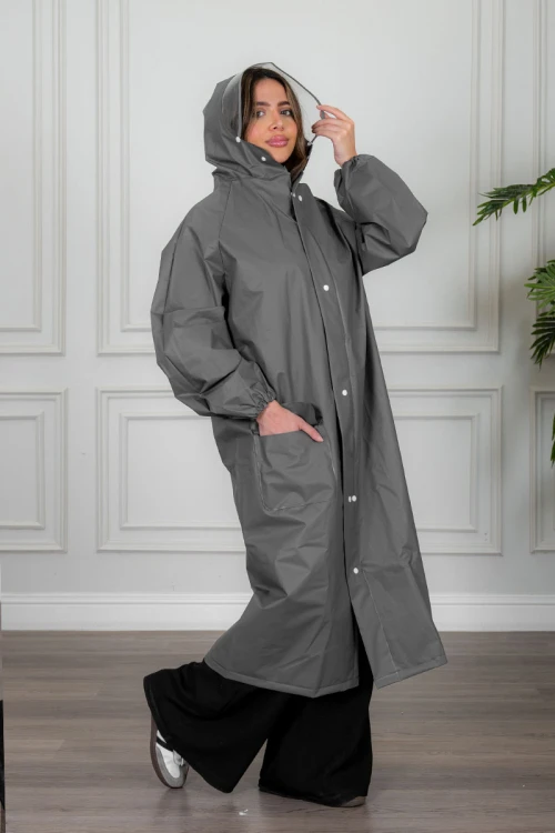 بالطو مطر نسائي لون رصاصي بقبعة متصلة بأزرار و سحاب و جيوب من الأمام و بأكمام طويلة