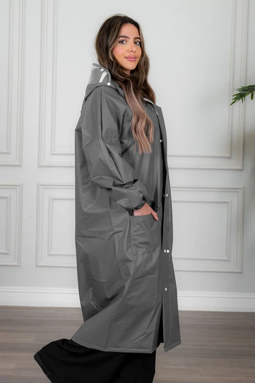 بالطو مطر نسائي لون رصاصي بقبعة متصلة بأزرار و سحاب و جيوب من الأمام و بأكمام طويلة
