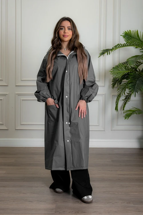 بالطو مطر نسائي لون رصاصي بقبعة متصلة بأزرار و سحاب و جيوب من الأمام و بأكمام طويلة