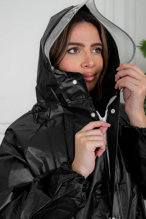 بالطو مطر نسائي لون أسود بقبعة متصلة بأزرار و سحاب و جيوب من الأمام و بأكمام طويلة