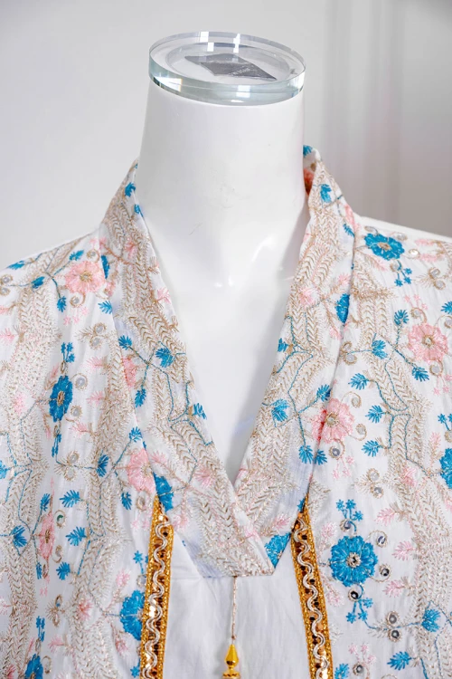 جلابية نسائي لون اوف وايت مزينة بورود ملونة و بكلفة ذهبية في الأطراف ياقة عالية بقصة سبعة و أكمام طويلة