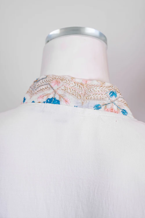 جلابية نسائي لون اوف وايت مزينة بورود ملونة و بكلفة ذهبية في الأطراف ياقة عالية بقصة سبعة و أكمام طويلة