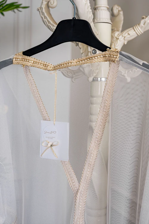 بشت نسائي لون بيج فاتح مزين بتطريز ذهبي في الأطراف