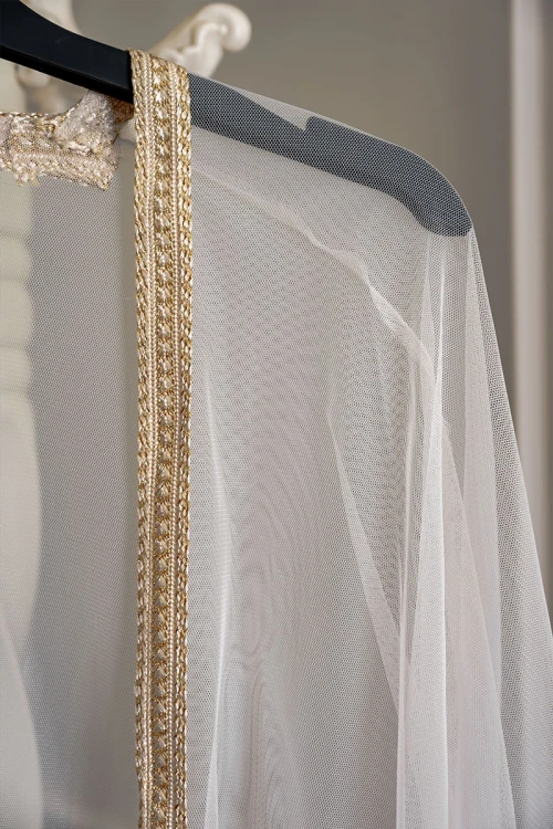 بشت نسائي لون بيج فاتح مزين بتطريز ذهبي في الأطراف