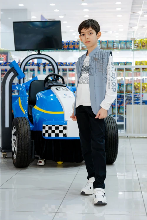 طقم ولادي 3 قطع بلوفر أبيض بكتابات و جاكيت سماوي بياقة عالية بدون أكمام مزين بزخارف مع بنطلون أسود طويل