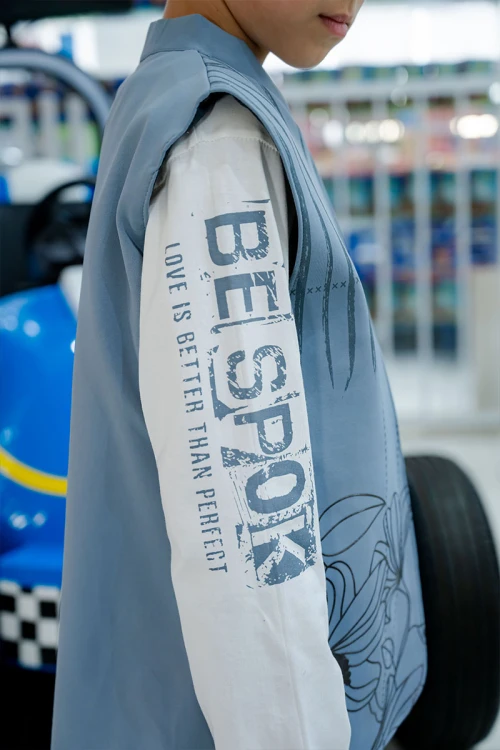 طقم ولادي 3 قطع بلوفر أبيض بكتابات و جاكيت سماوي بياقة عالية بدون أكمام مزين بزخارف مع بنطلون أسود طويل