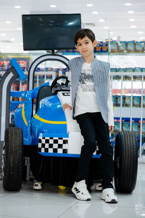 طقم ولادي 3 قطع بلوفر أبيض بكتابات و جاكيت سماوي بياقة عالية بدون أكمام مزين بزخارف مع بنطلون أسود طويل