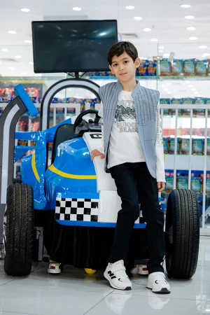 طقم ولادي 3 قطع بلوفر أبيض بكتابات و جاكيت سماوي بياقة عالية بدون أكمام مزين بزخارف مع بنطلون أسود طويل 