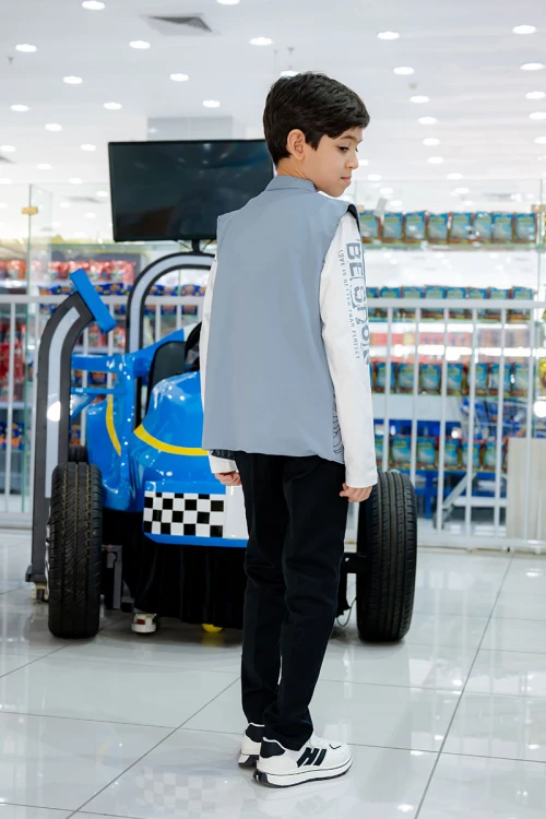 طقم ولادي 3 قطع بلوفر أبيض بكتابات و جاكيت سماوي بياقة عالية بدون أكمام مزين بزخارف مع بنطلون أسود طويل