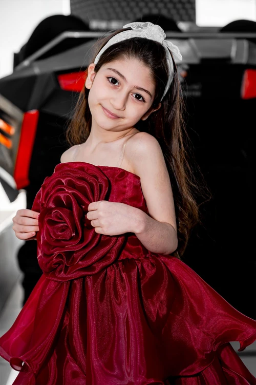 فستان بناتي لون عودي مزين بوردة كبيرة على الصدر بدون أكمام و بطبقات كشكش