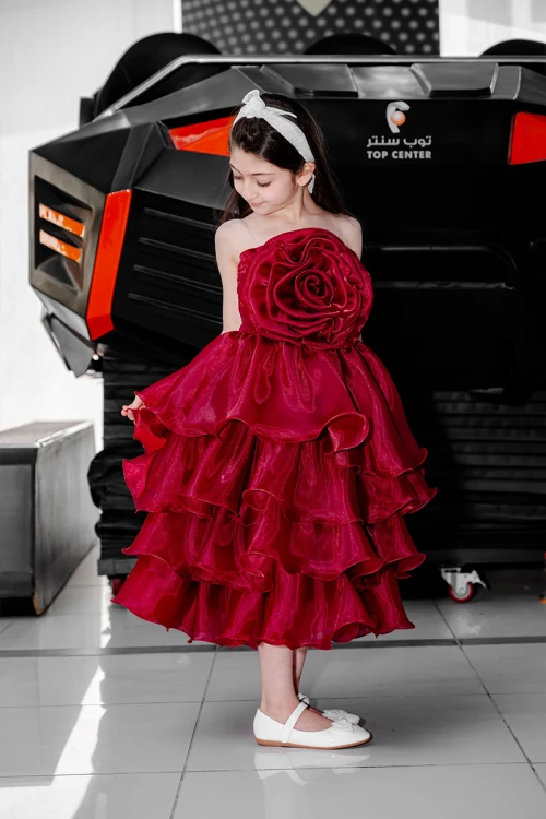 فستان بناتي لون عودي مزين بوردة كبيرة على الصدر بدون أكمام و بطبقات كشكش