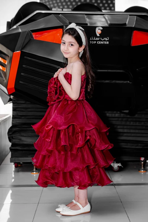 فستان بناتي لون عودي مزين بوردة كبيرة على الصدر بدون أكمام و بطبقات كشكش