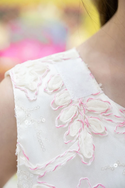 فستان بناتي لون أبيض ياقة دائرية بدون أكمام مزين بزهور و بوشاح تل منفصل على الكتف و برباط في الخصر