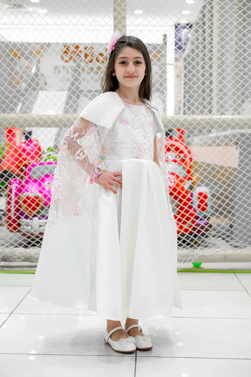 فستان بناتي لون أبيض ياقة دائرية بدون أكمام مزين بزهور و بوشاح تل منفصل على الكتف و برباط في الخصر