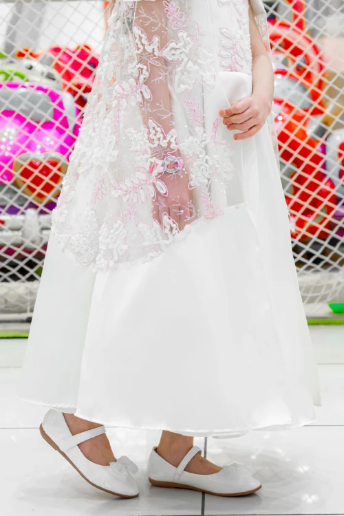 فستان بناتي لون أبيض ياقة دائرية بدون أكمام مزين بزهور و بوشاح تل منفصل على الكتف و برباط في الخصر