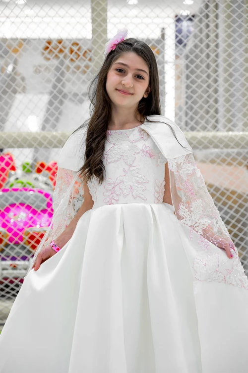 فستان بناتي لون أبيض ياقة دائرية بدون أكمام مزين بزهور و بوشاح تل منفصل على الكتف و برباط في الخصر