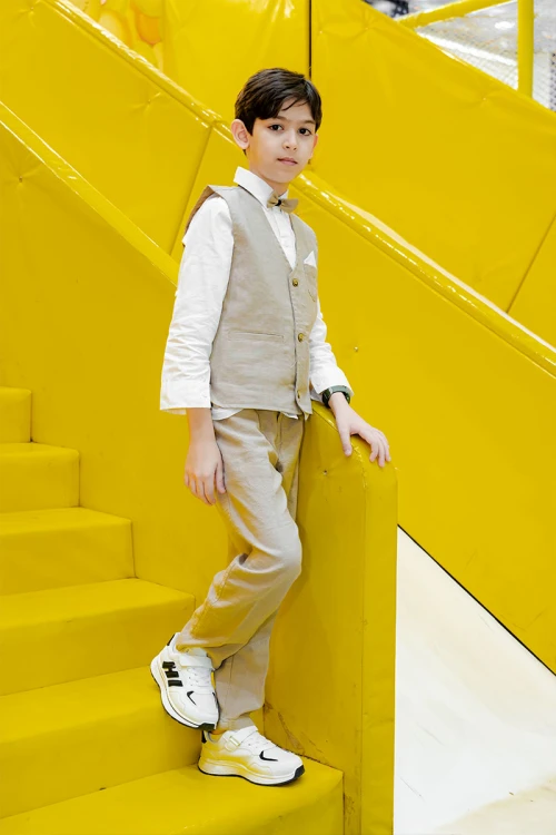 طقم ولادي 3 قطع بلوفر أبيض بكتابات و جاكيت سماوي بياقة عالية بدون أكمام مزين بزخارف مع بنطلون أسود طويل