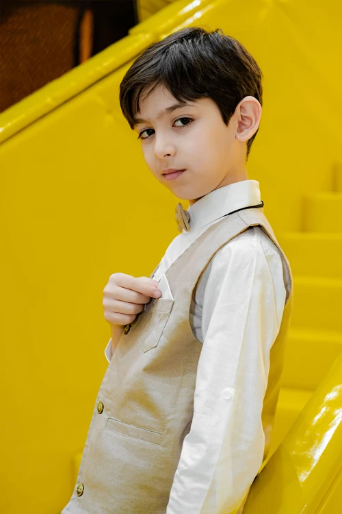 طقم ولادي 3 قطع بلوفر أبيض بكتابات و جاكيت سماوي بياقة عالية بدون أكمام مزين بزخارف مع بنطلون أسود طويل