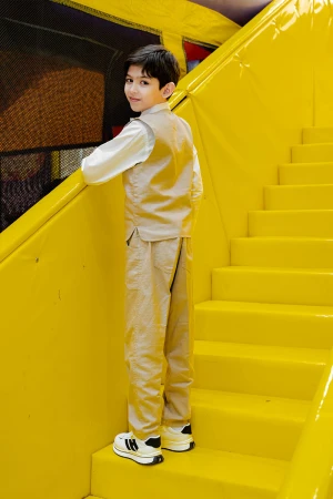 طقم ولادي 3 قطع بلوفر أبيض بكتابات و جاكيت سماوي بياقة عالية بدون أكمام مزين بزخارف مع بنطلون أسود طويل 