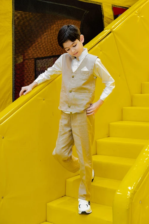 طقم ولادي 3 قطع بلوفر أبيض بكتابات و جاكيت سماوي بياقة عالية بدون أكمام مزين بزخارف مع بنطلون أسود طويل