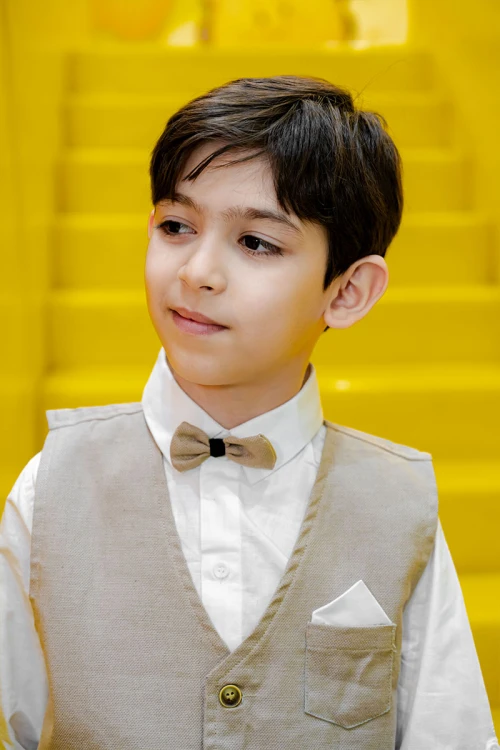 طقم ولادي 3 قطع بلوفر أبيض بكتابات و جاكيت سماوي بياقة عالية بدون أكمام مزين بزخارف مع بنطلون أسود طويل