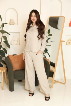 طقم نسائي قطعتين لون بيج قميص بياقة مطوية و أزرار من الأمام و أكمام طويلة مع بنطلون طويل بجيوب من الجانبين 