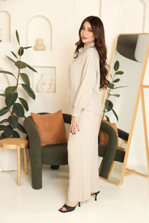 طقم نسائي قطعتين لون بيج قميص بياقة مطوية و أزرار من الأمام و أكمام طويلة مع بنطلون طويل بجيوب من الجانبين