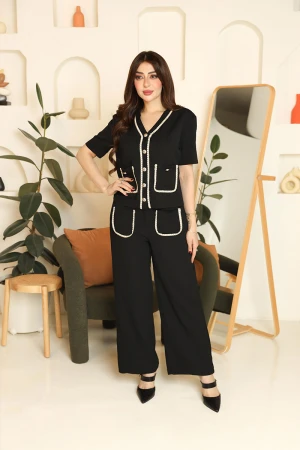 طقم نسائي قطعتين لون أسود مزين بحواف باللون البيج بلوزة بياقة قصة سبعة و أزرار من الأمام و أكمام قصيرة مع بنطلون طويل بجيوب من الأمام 