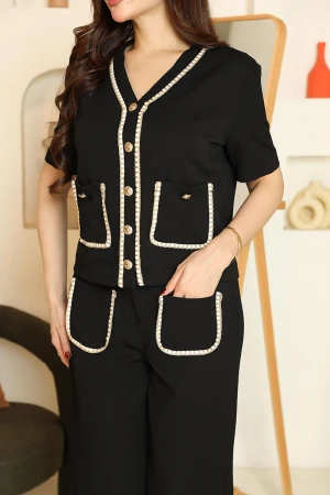 طقم نسائي قطعتين لون أسود مزين بحواف باللون البيج بلوزة بياقة قصة سبعة و أزرار من الأمام و أكمام قصيرة مع بنطلون طويل بجيوب من الأمام 