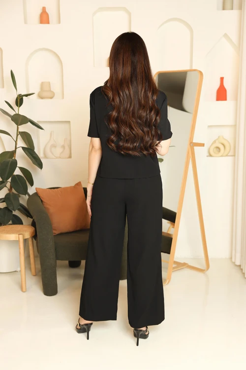 طقم نسائي قطعتين لون أسود مزين بحواف باللون البيج بلوزة بياقة قصة سبعة و أزرار من الأمام و أكمام قصيرة مع بنطلون طويل بجيوب من الأمام