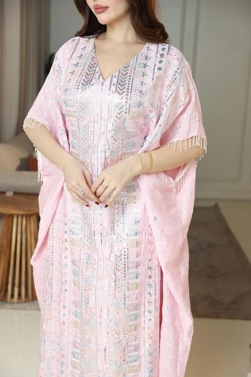 جلابية نسائية لون وردي فاتح مزينة بنقوش و تطريزات ملونة ياقة قصة سبعة و بأكمام ميدي