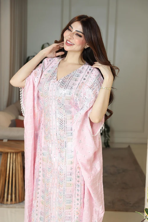 جلابية نسائية لون وردي فاتح مزينة بنقوش و تطريزات ملونة ياقة قصة سبعة و بأكمام ميدي