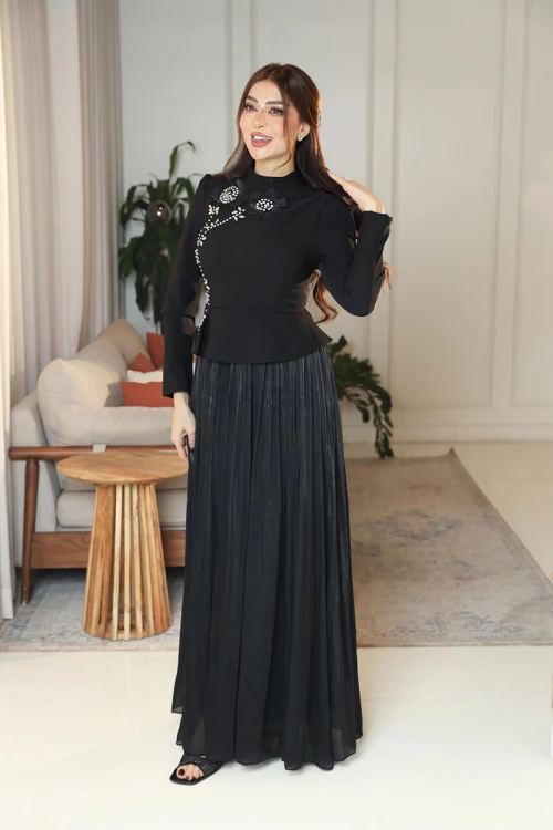 فستان نسائي لون أسود ياقة عالية بأكمام طويلة مزين بتطريزات على شكل زهور بكريستالات من الأمام مع تنورة كسرات