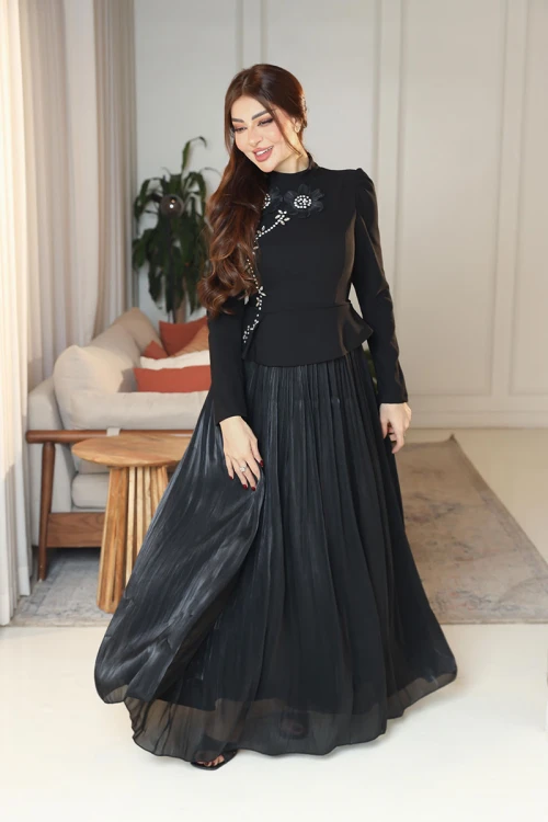فستان نسائي لون أسود ياقة عالية بأكمام طويلة مزين بتطريزات على شكل زهور بكريستالات من الأمام مع تنورة كسرات