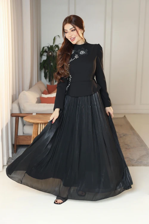 فستان نسائي لون أسود ياقة عالية بأكمام طويلة مزين بتطريزات على شكل زهور بكريستالات من الأمام مع تنورة كسرات