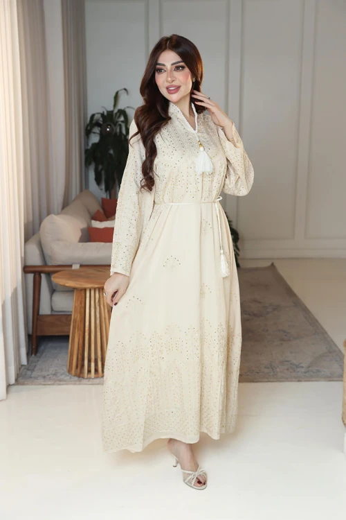 جلابية نسائية لون بيج ياقة عالية بقصة سبعة مزينة بالترتر و تطريزات ذهبية و بأكمام طويلة مع رباط في الخصر