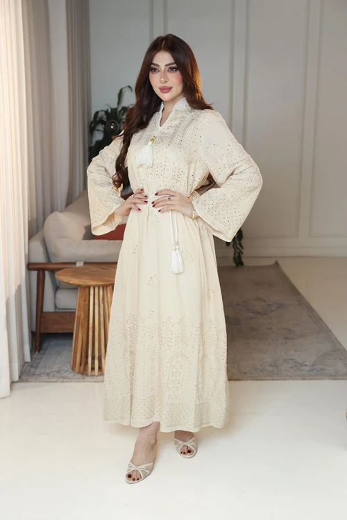 جلابية نسائية لون بيج ياقة عالية بقصة سبعة مزينة بالترتر و تطريزات ذهبية و بأكمام طويلة مع رباط في الخصر