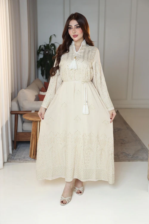 جلابية نسائية لون بيج ياقة عالية بقصة سبعة مزينة بالترتر و تطريزات ذهبية و بأكمام طويلة مع رباط في الخصر