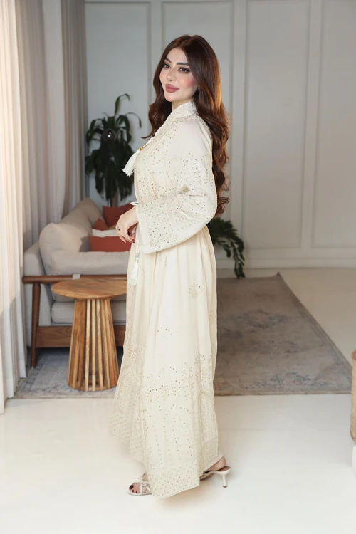 جلابية نسائية لون بيج ياقة عالية بقصة سبعة مزينة بالترتر و تطريزات ذهبية و بأكمام طويلة مع رباط في الخصر