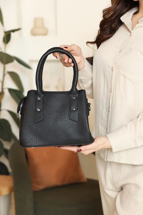 شنطة نسائية لون أسود مزينة باكسسوارات فضية