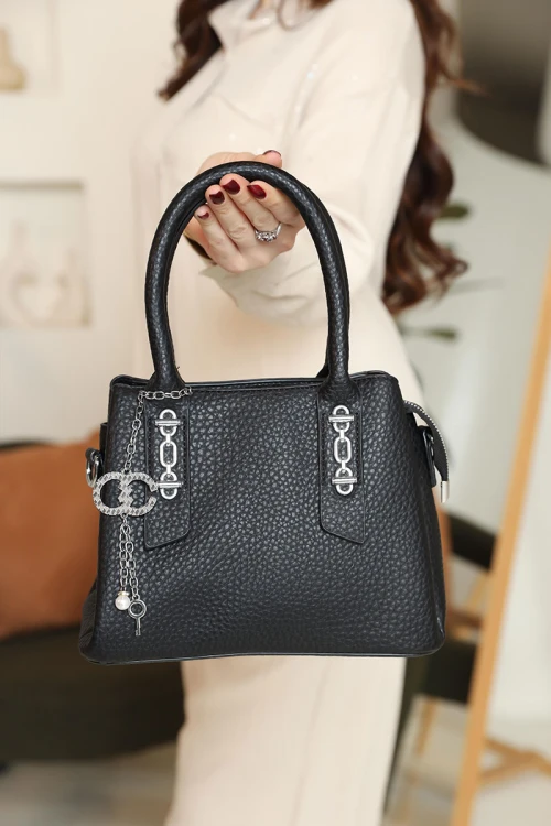 شنطة نسائية لون أسود مزينة باكسسوارات فضية